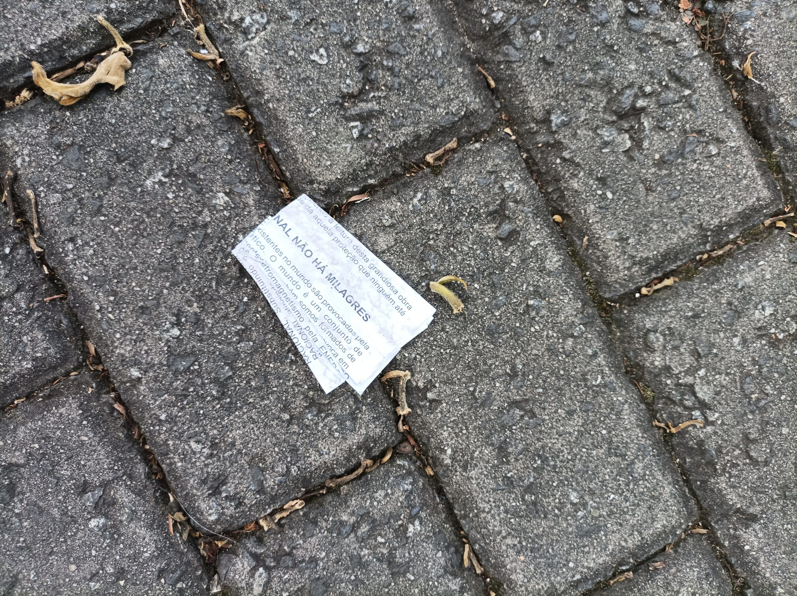 Um panfleto amassado jogando no chão de forma a destacar a frase "não há milagres"